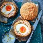 Golden brown Scotch Egg with crispy breadcrumb coating.